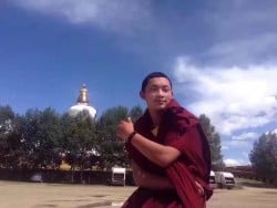 Mönch Lobsang Dhargya draußen vor Bäumen und Stupal