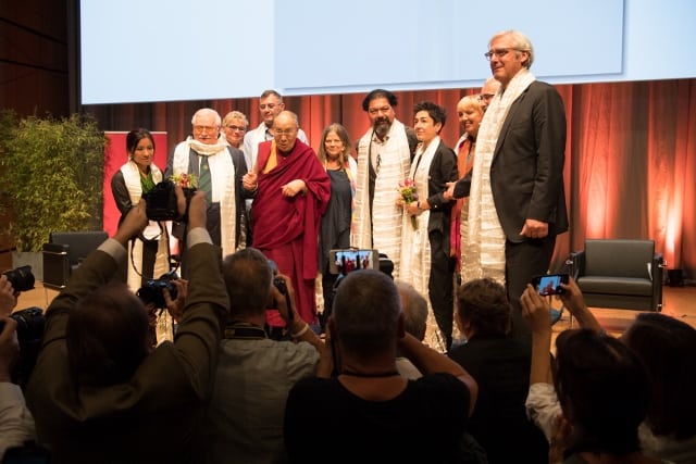 Gruppenfoto mit dem Dalai Lama, den Referenten, der Moderatorin, dem Cellisten Karim Wasfi, dem OB Jochen Partsch und unserem Vorsitzenden.